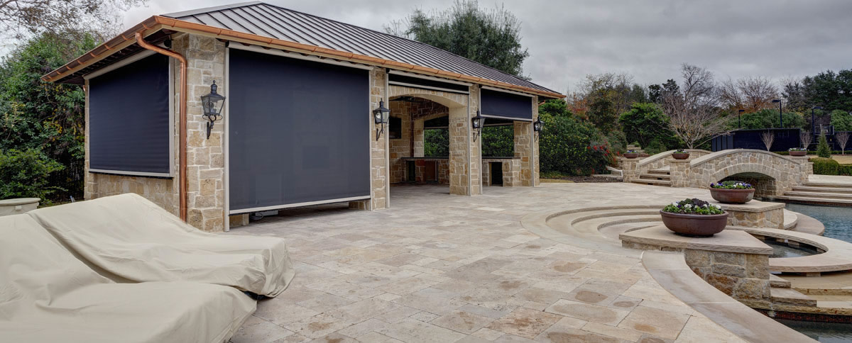 Stand-alone patio shelter with motorized retractable screens.
